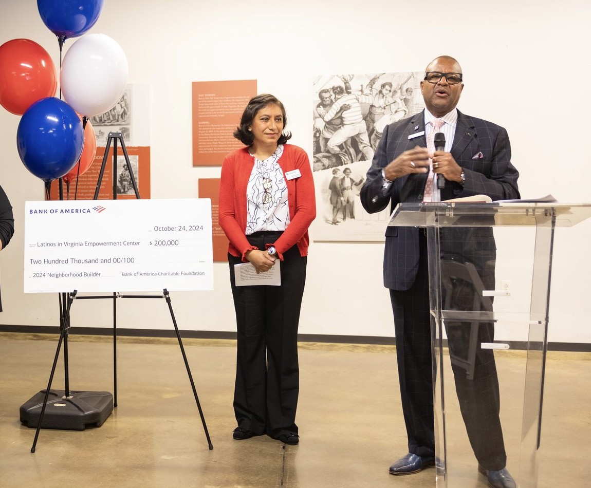 A Bank of America community investment check beside Elvira and the event speaker